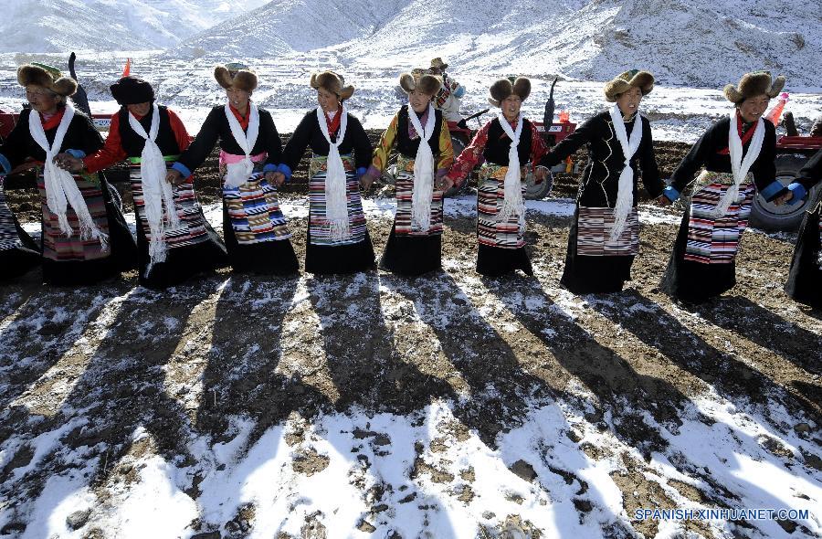 La foto muestra a un grupo de campesinos tibetanos bailando durante una ceremonia tradicional. 