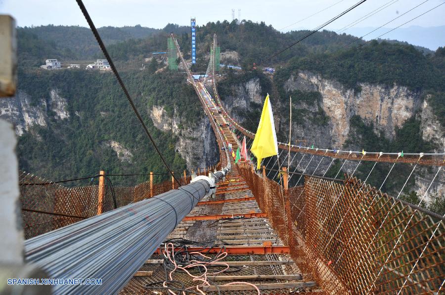 En el Parque Forestal Nacional de Zhangjiajie, un famoso lugar de interés turístico de la provincia central china de Hunan, se colocó hoy jueves la última viga del puente de vidrio más largo y alto del mundo, que se abrirá al público el 1 de mayo de 2016.