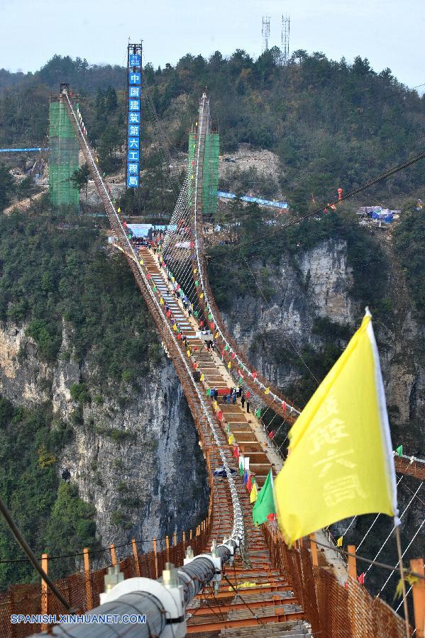 En el Parque Forestal Nacional de Zhangjiajie, un famoso lugar de interés turístico de la provincia central china de Hunan, se colocó hoy jueves la última viga del puente de vidrio más largo y alto del mundo, que se abrirá al público el 1 de mayo de 2016.
