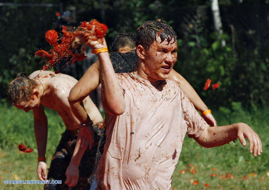 Jóvenes se arrojan tomates entre ellos durante el Festival Tomatina.
