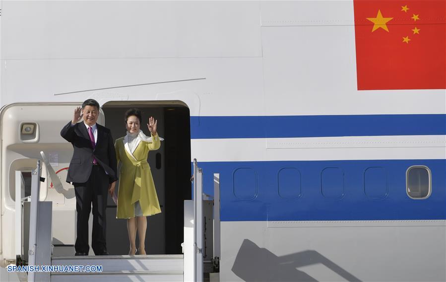 El presidente de China, Xi Jinping (i), y su esposa, Peng Liyuan, saludan a su llegada al aeropuerto en Quito, Ecuador, el 17 de noviembre de 2016.