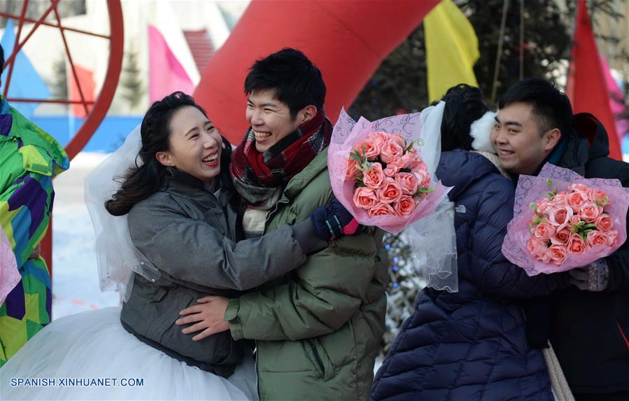 Parejas de recién casados asisten a una ceremonia de boda grupal en Harbin.