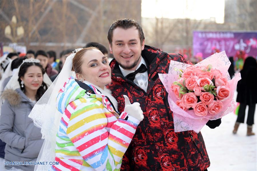 Parejas de recién casados asisten a una ceremonia de boda grupal en Harbin.