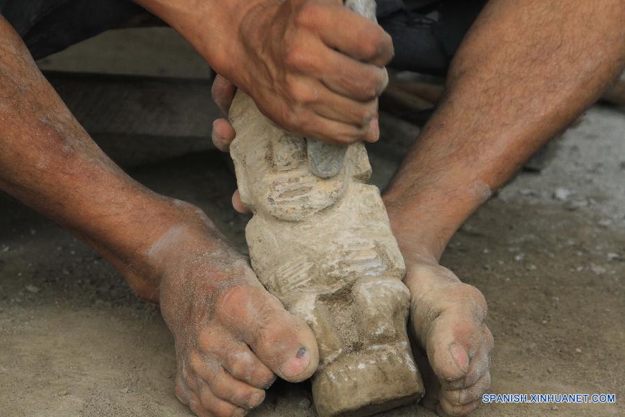 Fotografía tomada recientemente muestra a un artesano sosteniendo una réplica de ídolo precolombiano esculpida en piedra en San Juan de Oriente en el departamento de Masaya, Nicaragua.