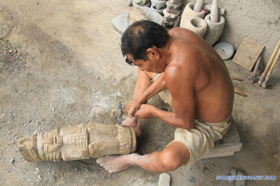 Fotografía tomada recientemente muestra a un artesano sosteniendo una réplica de ídolo precolombiano esculpida en piedra en San Juan de Oriente en el departamento de Masaya, Nicaragua.