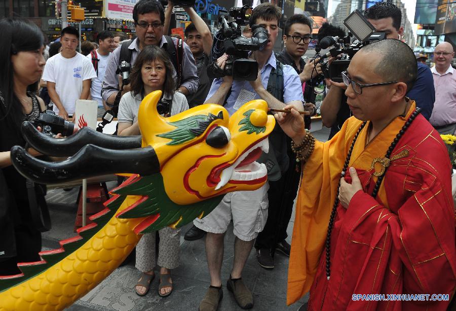 Un monje punteaba los ojos para un dragón durante la ceremonia de despertamiento de bote de dragón en la plaza Times Square en Nueva York, Estados Unidos el 7 de julio. El Festival Anual de Botes Dragón de Hong Kong en Nueva York se celebrará durante los días de 8 y 9 de agosto.  