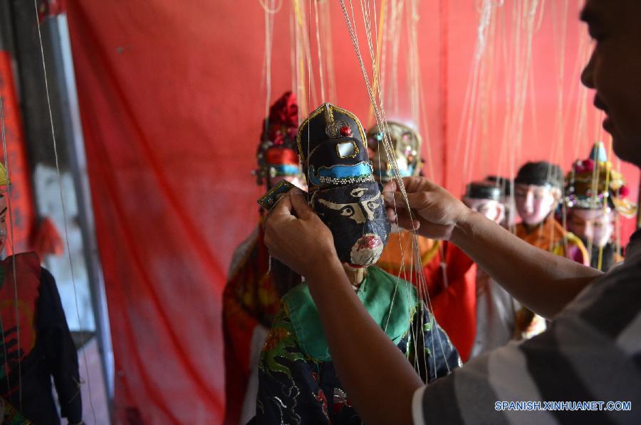 Un actor cambió maquillajes de las marionetas en una compañía de ópera  de marionetas en el municipio Tangfang, en el distrito Guangchang de la provincia oriental china de Jiangxi el 14 de julio. Actualmente en el municipio de Tangfang sólo hay una compañía  tradicional de de ópera de marionetas, que es popular entre los habitantes.