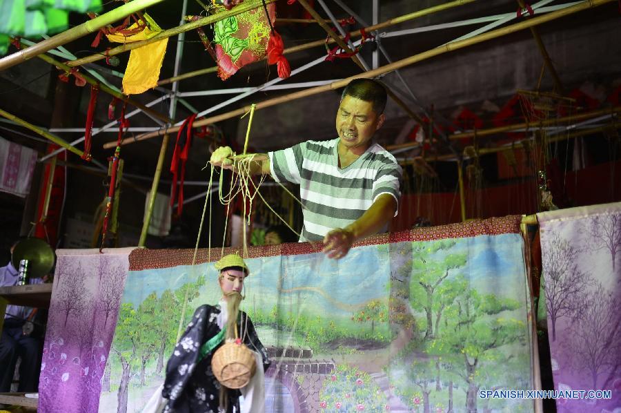 Un actor cambió maquillajes de las marionetas en una compañía de ópera  de marionetas en el municipio Tangfang, en el distrito Guangchang de la provincia oriental china de Jiangxi el 14 de julio. Actualmente en el municipio de Tangfang sólo hay una compañía  tradicional de de ópera de marionetas, que es popular entre los habitantes.