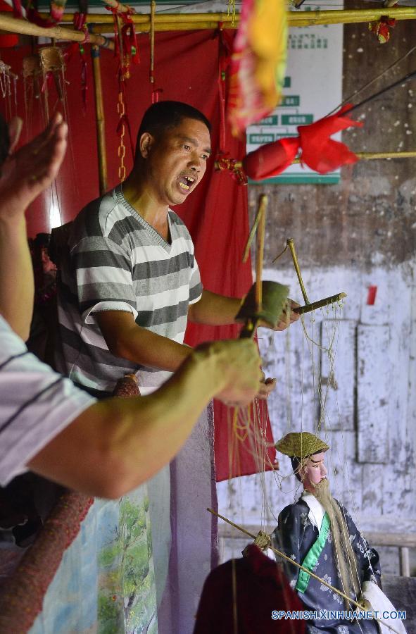 Un actor cambió maquillajes de las marionetas en una compañía de ópera  de marionetas en el municipio Tangfang, en el distrito Guangchang de la provincia oriental china de Jiangxi el 14 de julio. Actualmente en el municipio de Tangfang sólo hay una compañía  tradicional de de ópera de marionetas, que es popular entre los habitantes.