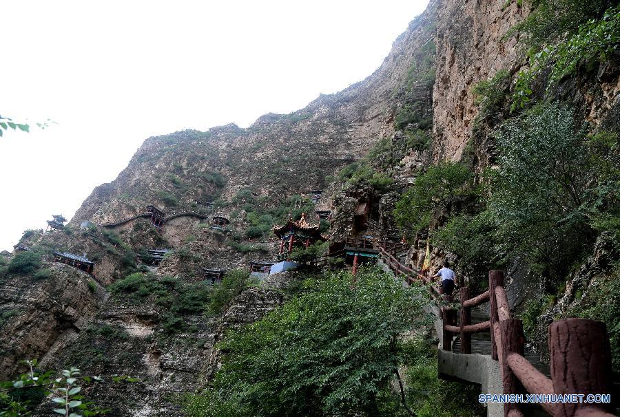 Turistas visitan antiguos templos taoístas construídos sobre acantilados del cañón del río Sanggan en el distrito Xuanhua, en la provincia norteña china de Hebei, el 20 de julio.