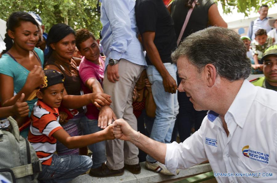 La imagen proporcionada por la presidencia colombiana muestra al presidente Juan Manuel Santos saludando a un níño durante su visita a las calles de la localidad de Oveja, Sucre, Colombia el 27 de julio.  