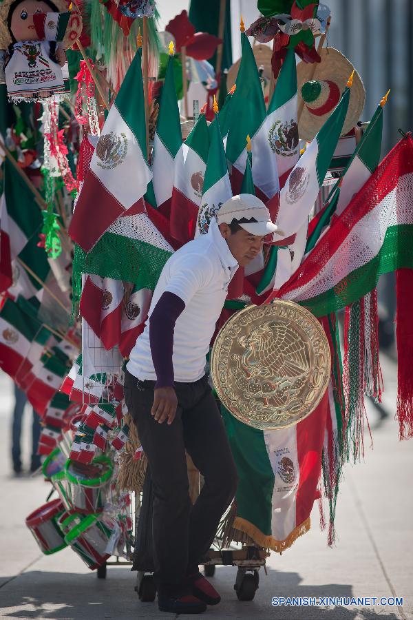 Un vendedor movía su mercancía enfrente del monumento de Revolución el 1 de septiembre, en la Ciudad de México, capital de México, que va a celebrar el 205 aniversario de la independencia del país.