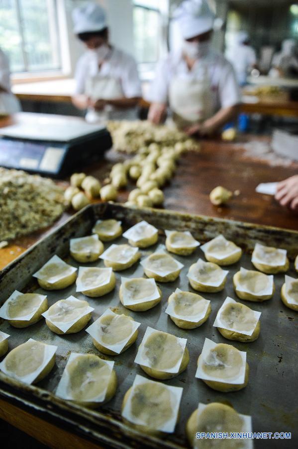 Trabajadores elaboraban pasteles de luna tradicionales en la panadería de Laodaogao en el antiguo pueblo de Tangqi en la ciudad Hangzhou, capital de la provincia oriental china de Zhejiang, el 22 de septiembre. La gente en China va a celebrar la fiesta de Medio Otoño el 27 de septiembre de este año, el quinzavo día del octavo mes en el calendaro lunar chino. Es una tradición comer pastel de luna y tener una reunión  familiar en el día. 