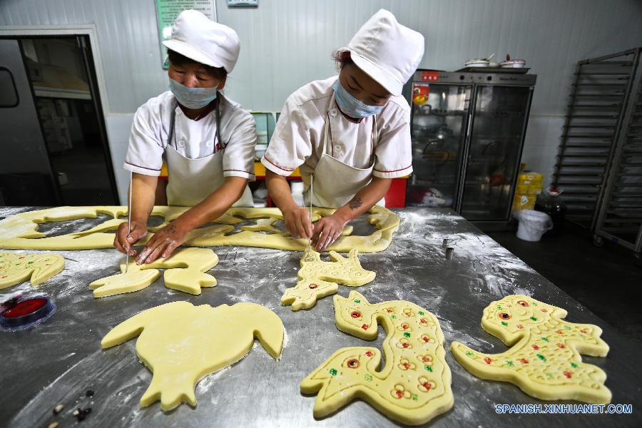 Trabajadores elaboraron pasteles de luna de forma de animales en un supermercado en Zhangye, de la provincia noroccidental china de Gansu el 22 de septiembre. La gente en China va a celebrar la fiesta de Medio Otoño el 27 de septiembre de este año, el quinzavo día del octavo mes en el calendaro lunar chino. Es una tradición comer pastel de luna y tener una reunión  familiar en el día.