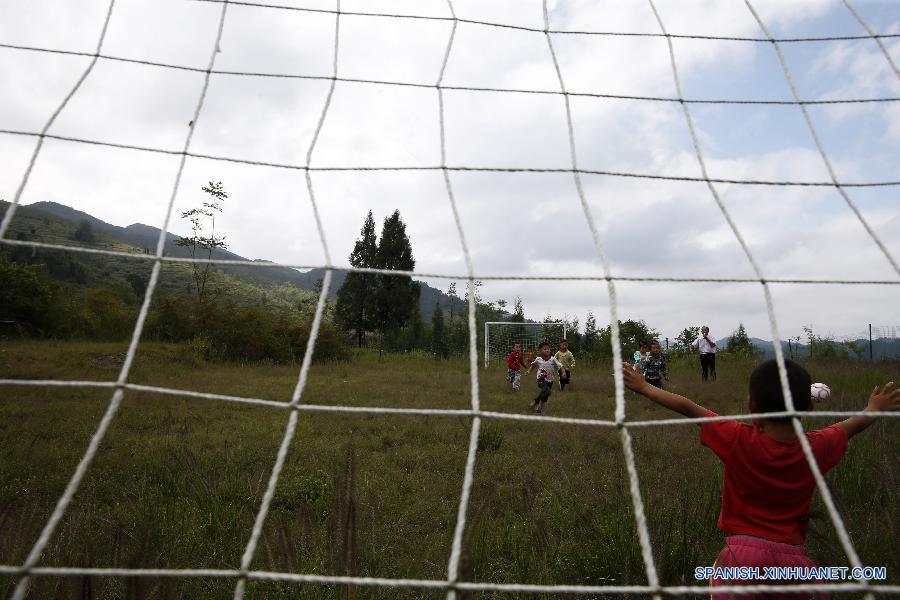 La foto tomada el 23 de septiembre de 2015 muestra a unos ni&ntilde;os jugando al f&uacute;tbol en una escuela primaria del pueblo Hongxing, que se encuentra en una zona monta&ntilde;osa de Chongqing, oeste de China. La escuela se trata de una microescuela que s&oacute;lo cuenta con 12 alumnos de primer curso y un maestro. Debido a la carencia de aparatos de deporte, los ni&ntilde;os sol&iacute;an jugar al f&uacute;tbol en un c&eacute;sped natural. En abril pasado, donaron a la escuela pelotas y porter&iacute;as, con lo que el c&eacute;sped se convirti&oacute; en una cancha real. Actualmente, los ni&ntilde;os pueden disfrutar el f&uacute;tbol a su costa. 