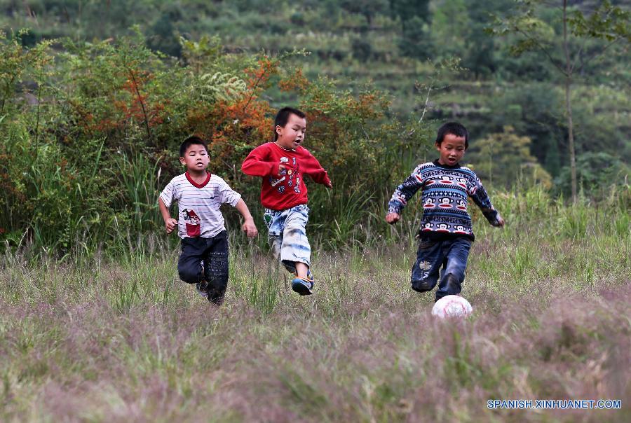 La foto tomada el 23 de septiembre de 2015 muestra a unos ni&ntilde;os jugando al f&uacute;tbol en una escuela primaria del pueblo Hongxing, que se encuentra en una zona monta&ntilde;osa de Chongqing, oeste de China. La escuela se trata de una microescuela que s&oacute;lo cuenta con 12 alumnos de primer curso y un maestro. Debido a la carencia de aparatos de deporte, los ni&ntilde;os sol&iacute;an jugar al f&uacute;tbol en un c&eacute;sped natural. En abril pasado, donaron a la escuela pelotas y porter&iacute;as, con lo que el c&eacute;sped se convirti&oacute; en una cancha real. Actualmente, los ni&ntilde;os pueden disfrutar el f&uacute;tbol a su costa. 