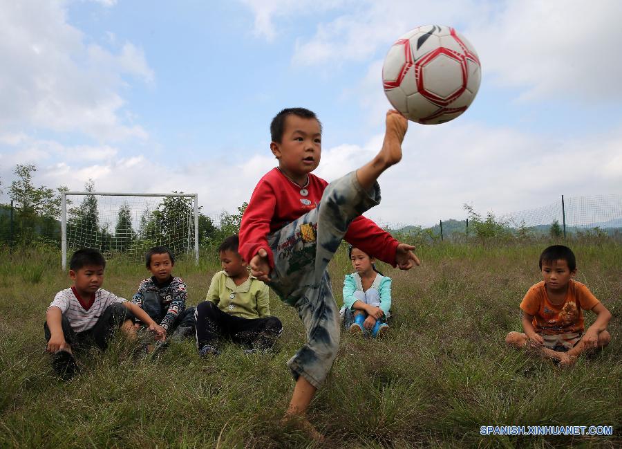 La foto tomada el 23 de septiembre de 2015 muestra a unos ni&ntilde;os jugando al f&uacute;tbol en una escuela primaria del pueblo Hongxing, que se encuentra en una zona monta&ntilde;osa de Chongqing, oeste de China. La escuela se trata de una microescuela que s&oacute;lo cuenta con 12 alumnos de primer curso y un maestro. Debido a la carencia de aparatos de deporte, los ni&ntilde;os sol&iacute;an jugar al f&uacute;tbol en un c&eacute;sped natural. En abril pasado, donaron a la escuela pelotas y porter&iacute;as, con lo que el c&eacute;sped se convirti&oacute; en una cancha real. Actualmente, los ni&ntilde;os pueden disfrutar el f&uacute;tbol a su costa. 