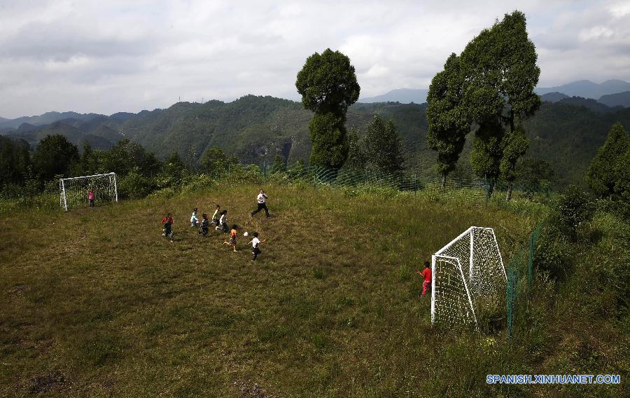 La foto tomada el 23 de septiembre de 2015 muestra a unos ni&ntilde;os jugando al f&uacute;tbol en una escuela primaria del pueblo Hongxing, que se encuentra en una zona monta&ntilde;osa de Chongqing, oeste de China. La escuela se trata de una microescuela que s&oacute;lo cuenta con 12 alumnos de primer curso y un maestro. Debido a la carencia de aparatos de deporte, los ni&ntilde;os sol&iacute;an jugar al f&uacute;tbol en un c&eacute;sped natural. En abril pasado, donaron a la escuela pelotas y porter&iacute;as, con lo que el c&eacute;sped se convirti&oacute; en una cancha real. Actualmente, los ni&ntilde;os pueden disfrutar el f&uacute;tbol a su costa. 