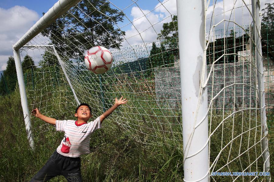 La foto tomada el 23 de septiembre de 2015 muestra a unos ni&ntilde;os jugando al f&uacute;tbol en una escuela primaria del pueblo Hongxing, que se encuentra en una zona monta&ntilde;osa de Chongqing, oeste de China. La escuela se trata de una microescuela que s&oacute;lo cuenta con 12 alumnos de primer curso y un maestro. Debido a la carencia de aparatos de deporte, los ni&ntilde;os sol&iacute;an jugar al f&uacute;tbol en un c&eacute;sped natural. En abril pasado, donaron a la escuela pelotas y porter&iacute;as, con lo que el c&eacute;sped se convirti&oacute; en una cancha real. Actualmente, los ni&ntilde;os pueden disfrutar el f&uacute;tbol a su costa. 