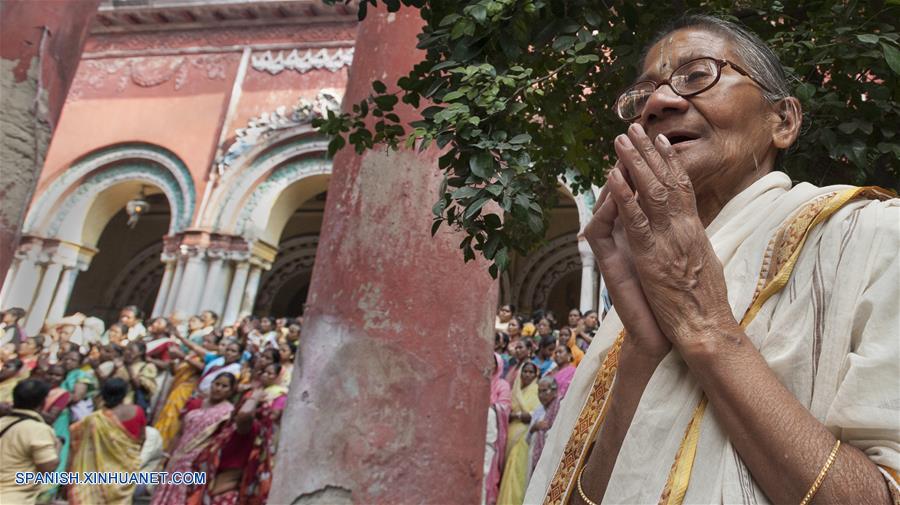 Una devota india extiende su sari para recolectar arroz para celebrar el ritual de Annakut, que consiste en pedir arroz a los dioses durante el segundo día del festival de Diwali en Culcata, India. Diwali, el festival hindú de la luz, simboliza la vuelta del diós indio Rama después de su triunfo sobre el rey de demonio Ravana.