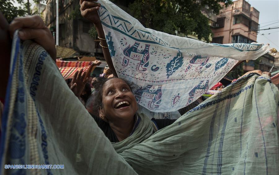 Una devota india extiende su sari para recolectar arroz para celebrar el ritual de Annakut, que consiste en pedir arroz a los dioses durante el segundo día del festival de Diwali en Culcata, India. Diwali, el festival hindú de la luz, simboliza la vuelta del diós indio Rama después de su triunfo sobre el rey de demonio Ravana.