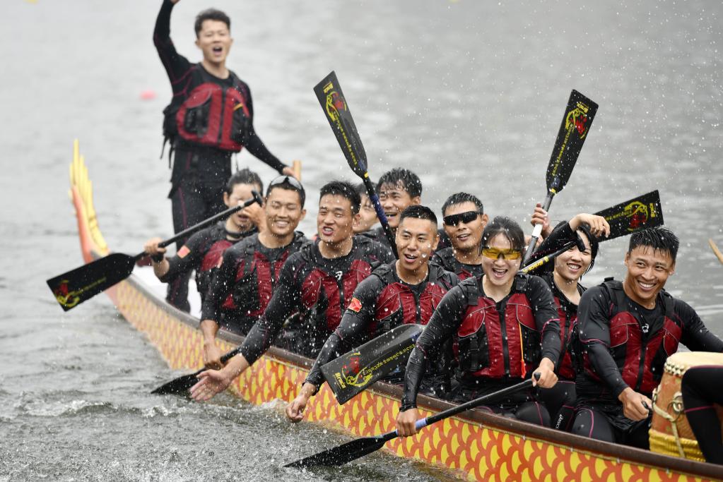 Personas participan en carrera de bote de dragón para celebrar Festival del Bote de Dragón en Tianjin