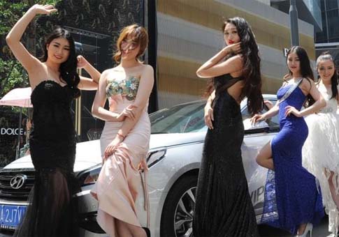 Modelos posan con coches en calles de Chengdu