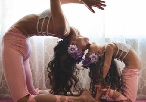 La mujer hace yoga con sus niños