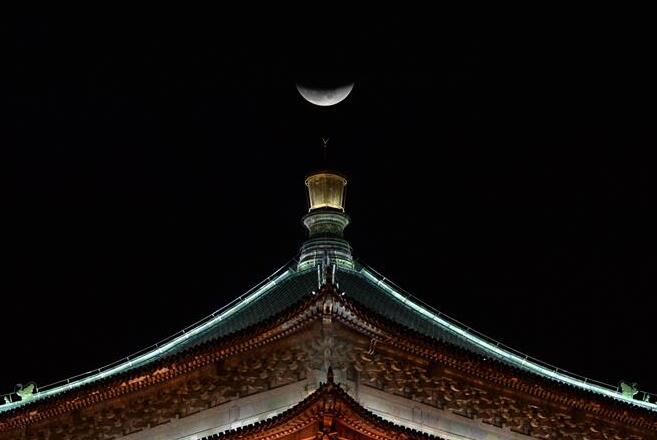 La Luna se eleva sobre una torre del reloj en Xi'an
