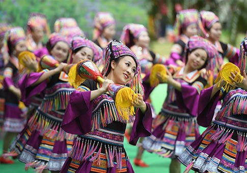 Personas de minorías étnicas bailan para recibir el festival "San Yue San" en Liuzhou
