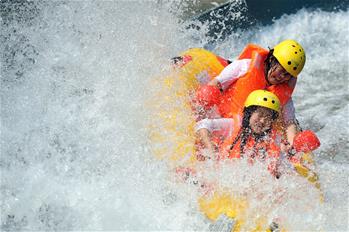 Turistas se desplazan a través del torrente de agua en Chengde