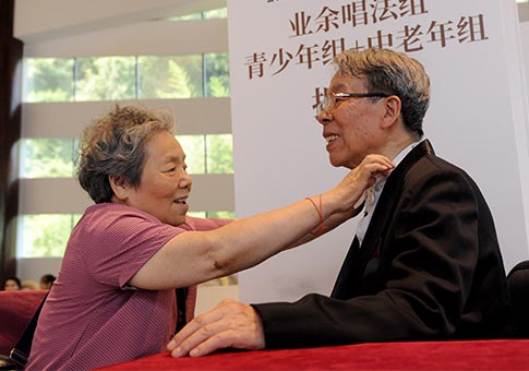 Anciano chino quien persigue su sueño de canto acompañado por su esposa
