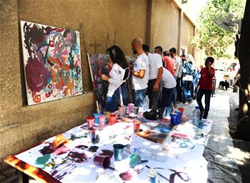 Personas realizan pinturas en una calle en Damasco