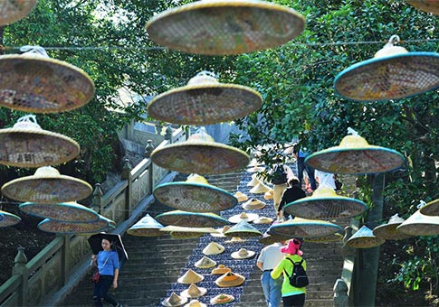 Guangxi: Escalones de piedra decorados con sombreros de lluvia de bambú en Yushilin