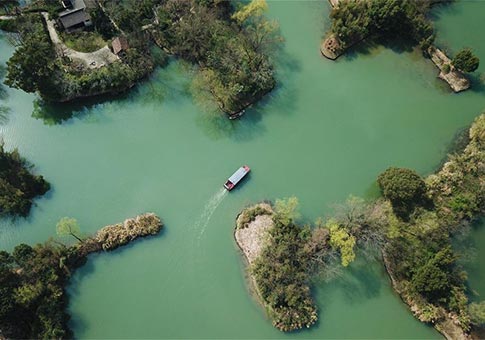 Vista aérea de visitantes tomando botes para recorrer el Parque Nacional de Humedales Xixi en Hangzhou