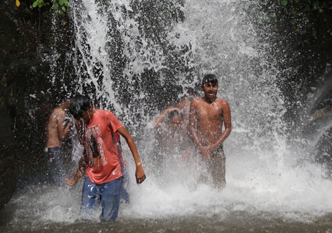 Personas se refrescan bajo cascada en Nepal