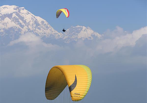 Turistas vuelan en parapente sobre un valle en Pokhara, Nepal