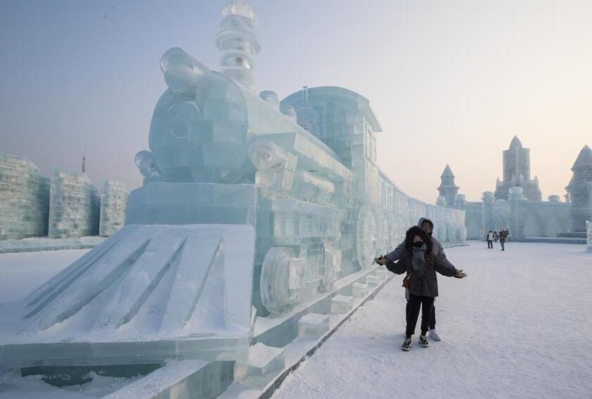 Turistas observan las esculturas de hielo en el Mundo de Hielo y Nieve de Harbin