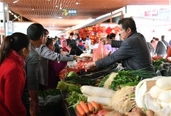 Yunnan: Personas compran productos en una feria para saludar el próximo Festival de Primavera en Qujing