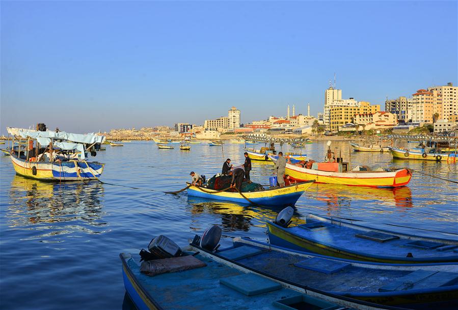 Pescadores palestinos trabajan en su bote en un puerto marítimo en Gaza