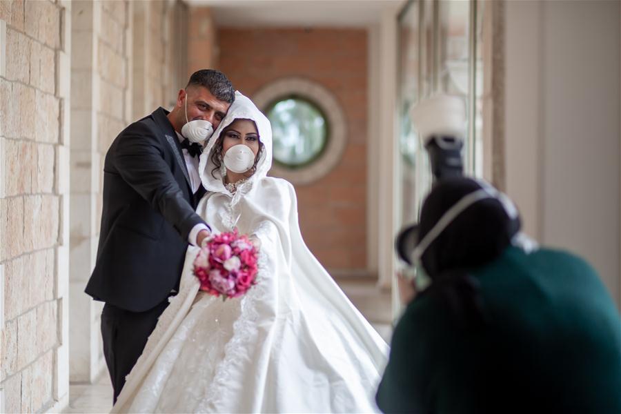 Pareja palestina celebra su boda usando mascarillas y guantes