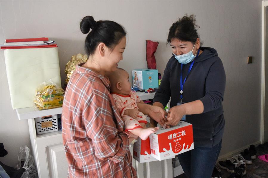 Trabajadora comunitaria entregan leche a las familias en Urumqi