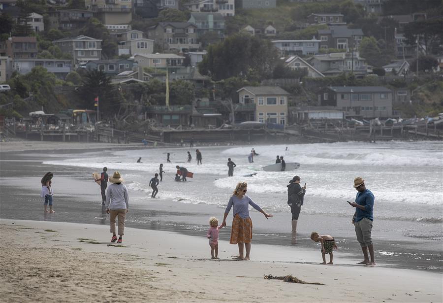 Personas se divierten en la playa Pacífica en California