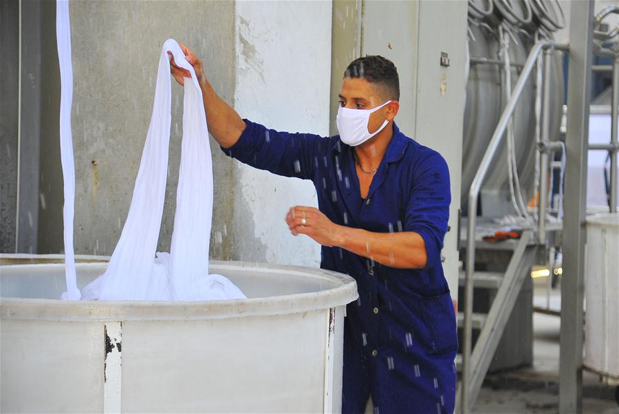 Trabajadores sirios fabrican mascarillas en un taller en Damasco
