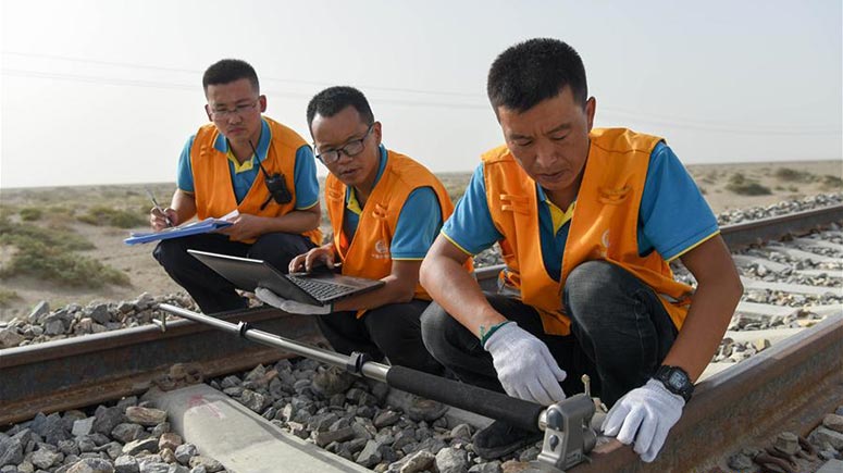 Trabajadores de mantenimiento ferroviario revisan las irregularidades sobre la línea del ferrocarril Golmud-Korla en Xinjiang