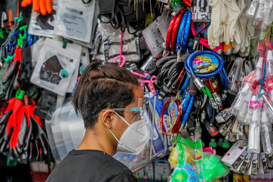 Personas portan mascarillas y caretas en un mercado en Manila, Filipinas