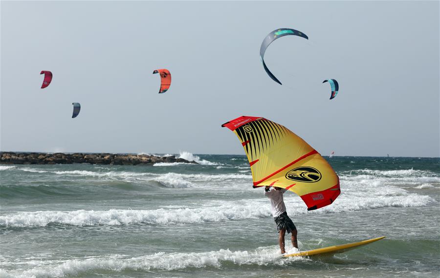 Israelíes practican kitesurfing en la playa en Tel Aviv