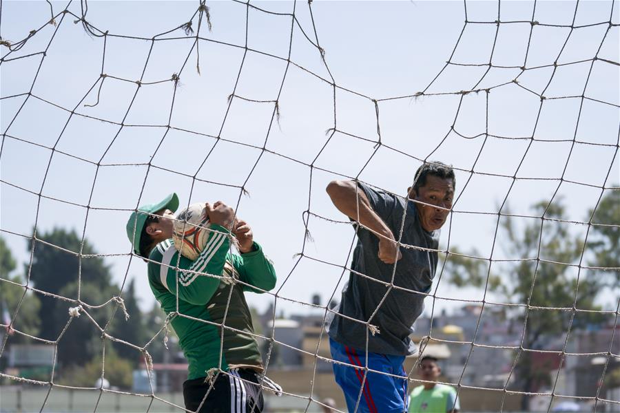 Partido de fútbol en cancha de parque en la Ciudad de México