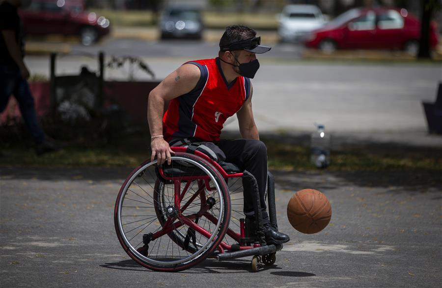 Personas con discapacidad portan mascarillas mientras juegan baloncesto en Quito