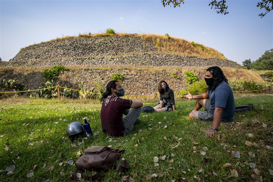 Visitantes portan mascarillas mientras visitan la Pirámide de Cuicuilco en la Ciudad de México